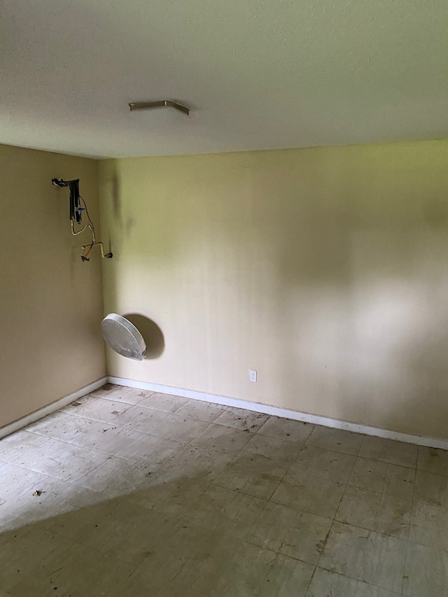 tiled empty room with a textured ceiling