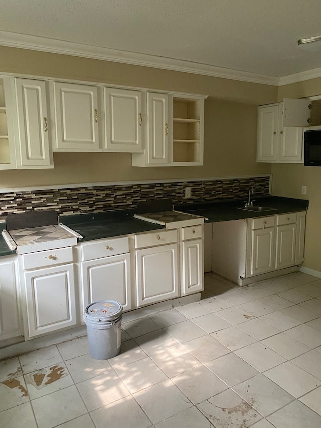 kitchen featuring white cabinets, sink, tasteful backsplash, and light tile floors