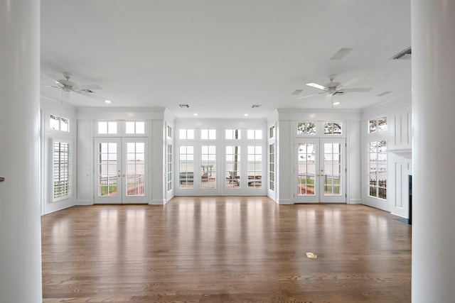 unfurnished living room featuring french doors, ceiling fan, and hardwood / wood-style floors