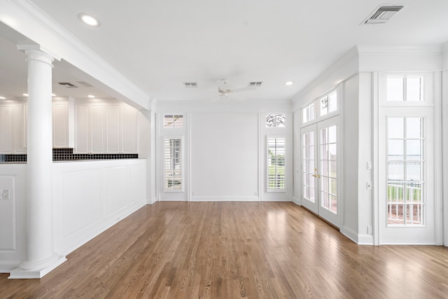 unfurnished room with ornate columns, hardwood / wood-style floors, ceiling fan, and crown molding