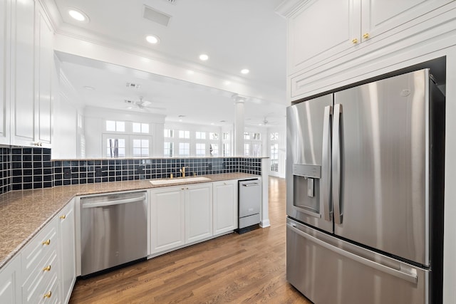 kitchen with backsplash, ceiling fan, stainless steel appliances, and hardwood / wood-style flooring