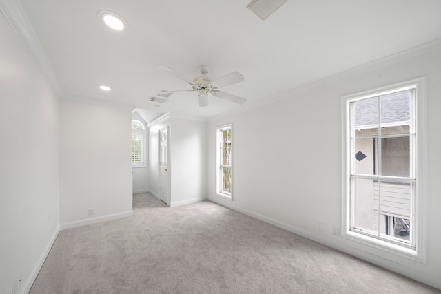 spare room with light carpet, plenty of natural light, and crown molding