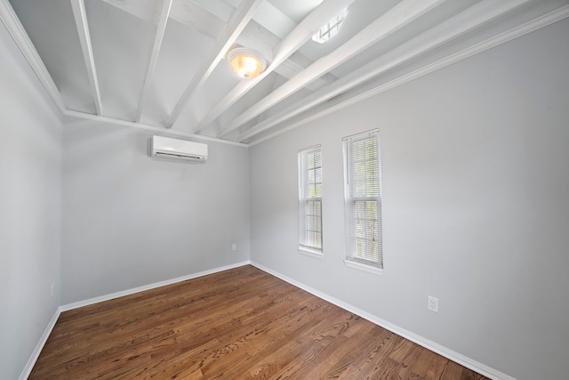 spare room featuring beamed ceiling, wood-type flooring, and an AC wall unit