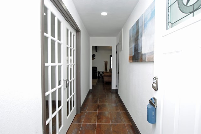 hall featuring dark tile flooring and french doors