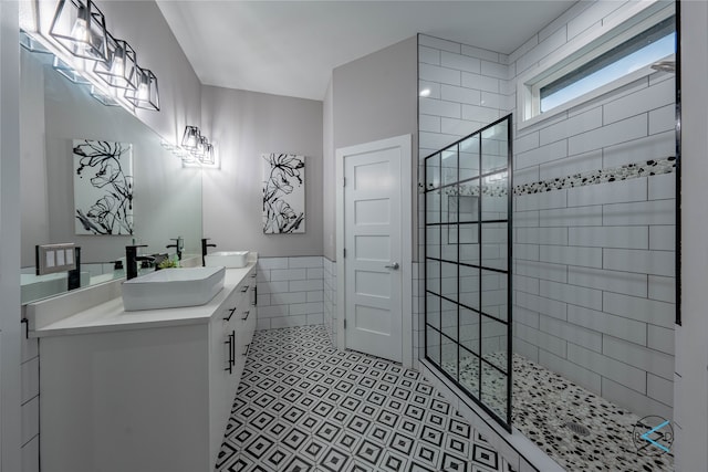 bathroom featuring vanity with extensive cabinet space, tile walls, dual sinks, walk in shower, and tile floors