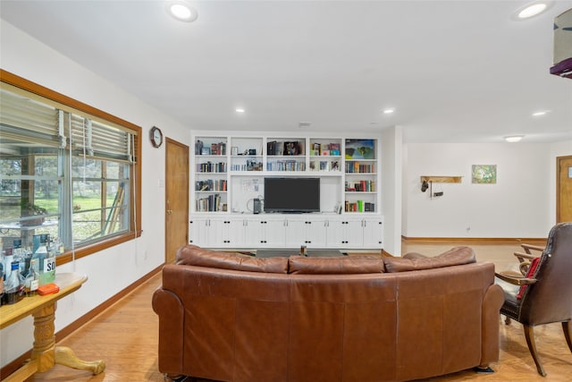 living room with light hardwood / wood-style flooring and built in shelves