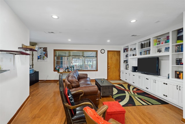 living room featuring light hardwood / wood-style floors and built in shelves