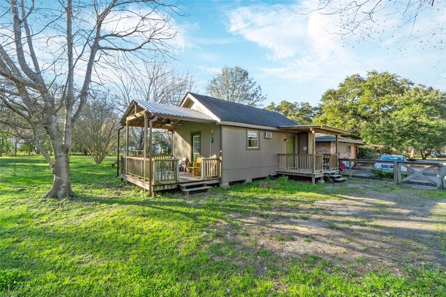 rear view of house with a deck and a lawn