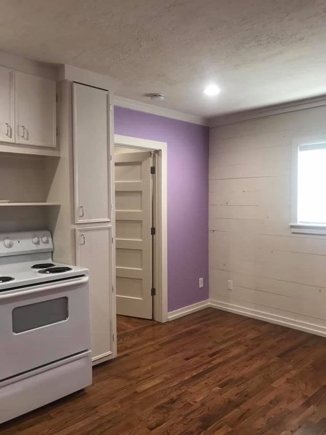 kitchen with a textured ceiling, white cabinets, white range with electric stovetop, dark wood-type flooring, and ornamental molding