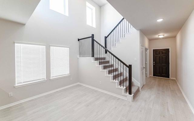 stairway with a high ceiling and hardwood / wood-style flooring