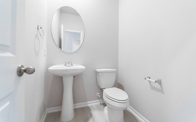 bathroom featuring hardwood / wood-style flooring and toilet