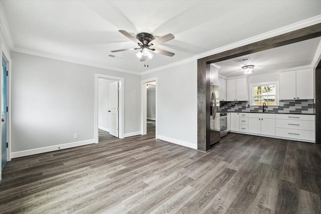 kitchen featuring tasteful backsplash, dark wood-type flooring, stainless steel appliances, ceiling fan, and white cabinets