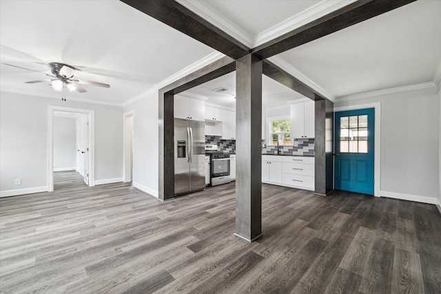 unfurnished living room with ceiling fan, ornamental molding, and dark hardwood / wood-style flooring