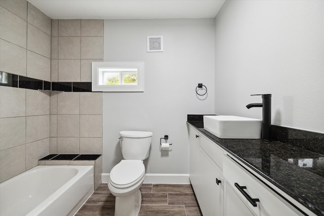 bathroom with hardwood / wood-style floors, a bathtub, toilet, and vanity