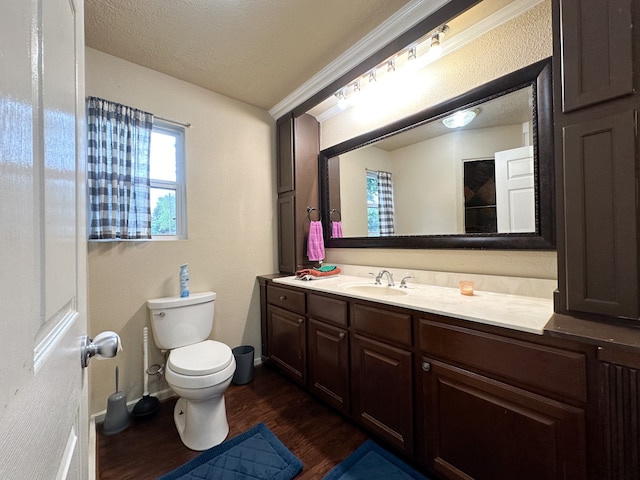 bathroom featuring vanity, ornamental molding, hardwood / wood-style flooring, toilet, and a textured ceiling