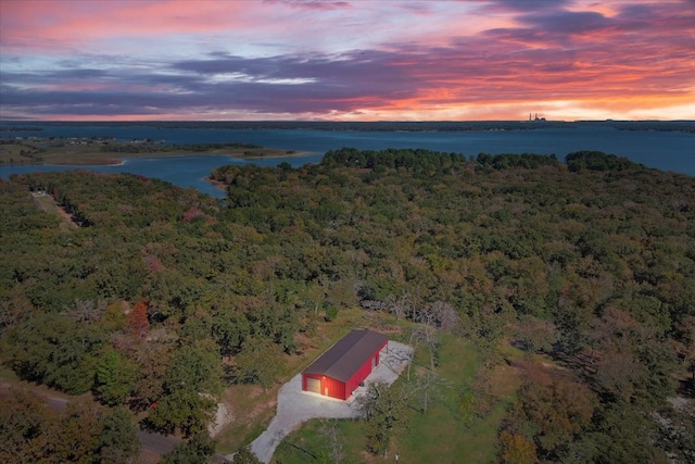 aerial view at dusk featuring a water view