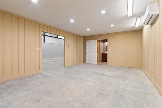 empty room featuring a textured ceiling, an AC wall unit, and wooden walls