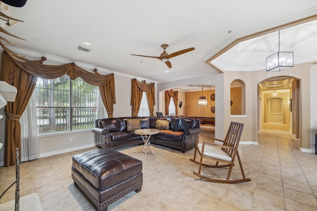 tiled living room with ceiling fan with notable chandelier and ornamental molding