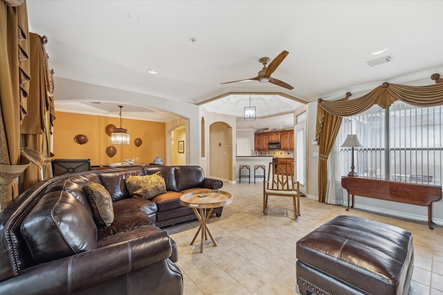 tiled living room with ceiling fan and ornamental molding