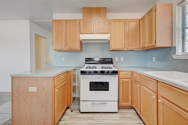 kitchen with light brown cabinetry, white gas stove, and light wood-type flooring