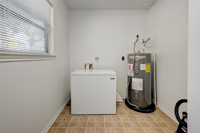 clothes washing area with light tile floors, hookup for a washing machine, and electric water heater