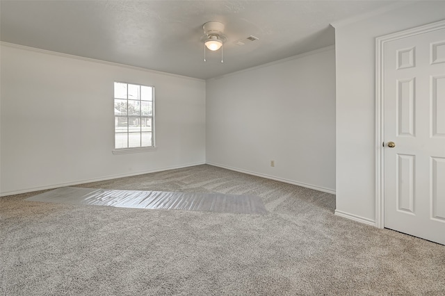 carpeted empty room with ceiling fan and crown molding