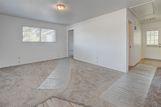 spare room with a textured ceiling and light tile flooring