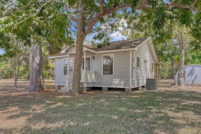 view of front of property with central air condition unit and a front yard