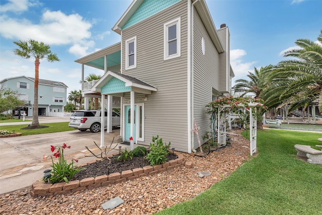 view of home's exterior featuring driveway and a yard