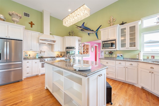 kitchen featuring visible vents, white cabinets, wall chimney exhaust hood, appliances with stainless steel finishes, and open shelves