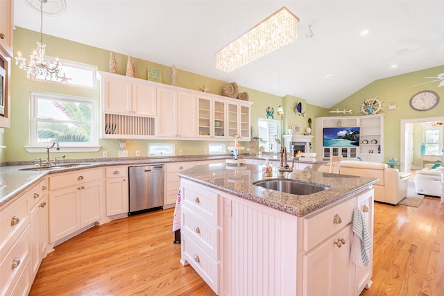 kitchen featuring dishwasher, open floor plan, plenty of natural light, and a sink