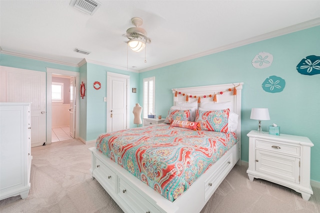 bedroom with ornamental molding, visible vents, light carpet, and a ceiling fan