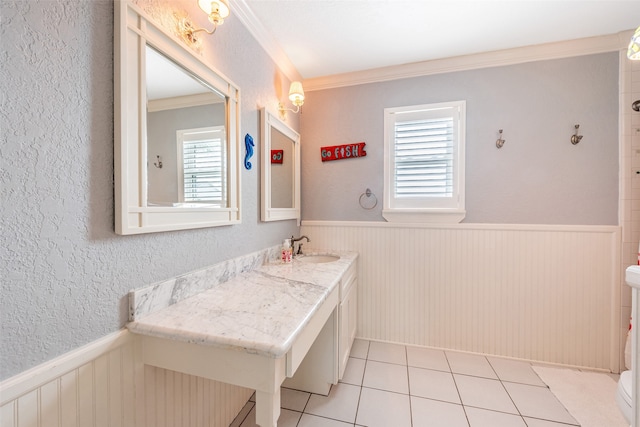 bathroom featuring ornamental molding, wainscoting, and toilet