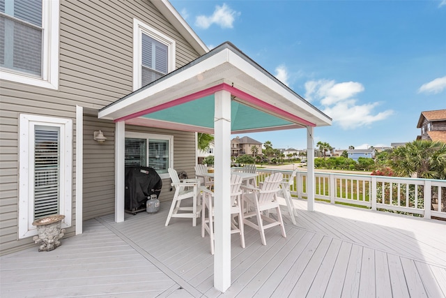 deck with outdoor dining space and a grill