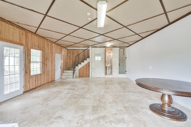 interior space with tile patterned floors and wood walls