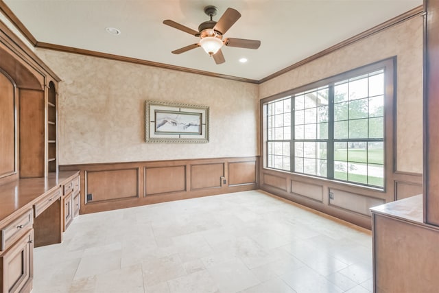 tiled spare room featuring built in desk, ceiling fan, and crown molding