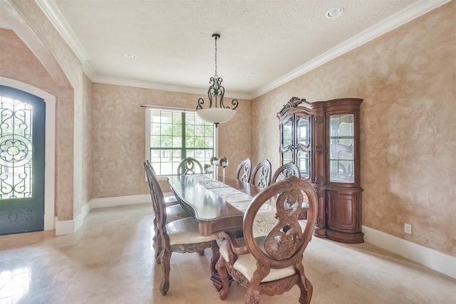 tiled dining room featuring crown molding and a textured ceiling