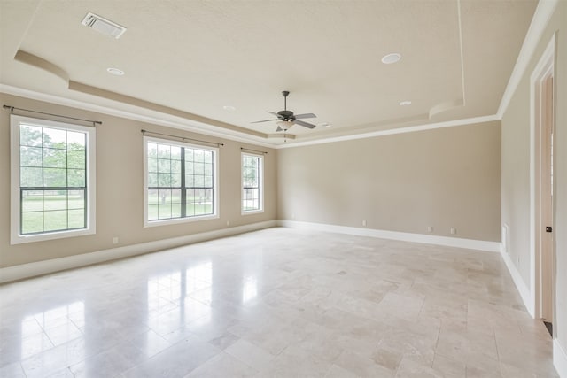 spare room featuring light tile patterned flooring, a raised ceiling, and a wealth of natural light