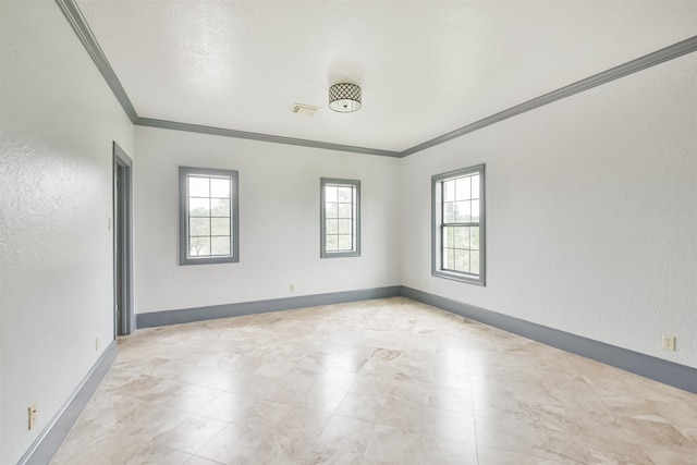 tiled spare room featuring crown molding and a wealth of natural light