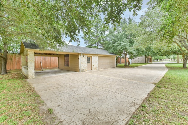 exterior space with a carport, a garage, and a front yard