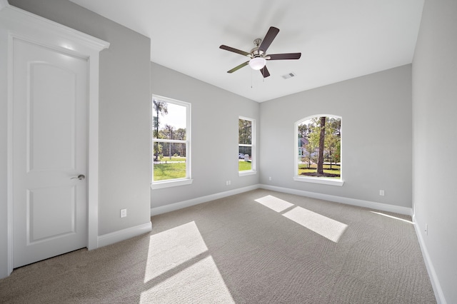 carpeted spare room with ceiling fan