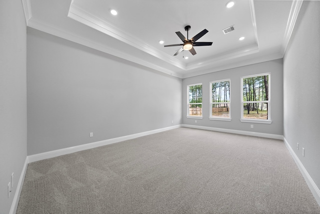 carpeted empty room featuring a raised ceiling, ceiling fan, and ornamental molding