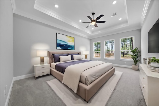 bedroom featuring light carpet, a raised ceiling, ceiling fan, and crown molding