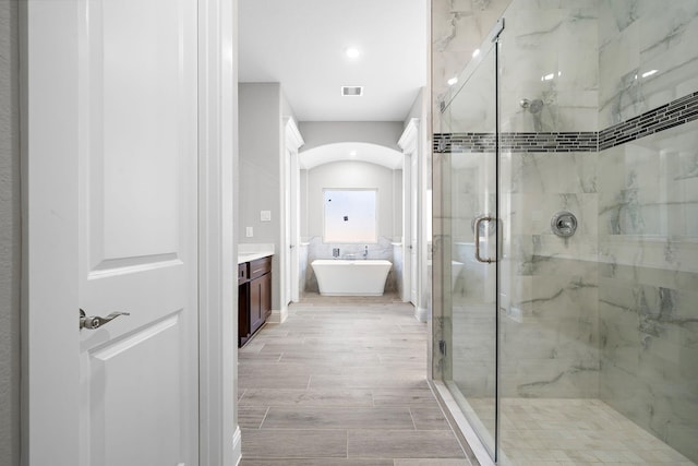 bathroom featuring plus walk in shower and vanity