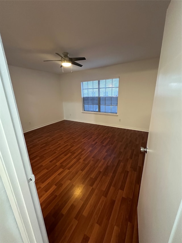 spare room featuring dark hardwood / wood-style flooring and ceiling fan