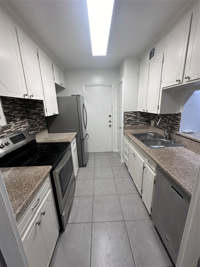 kitchen with white cabinets, sink, backsplash, and stainless steel appliances