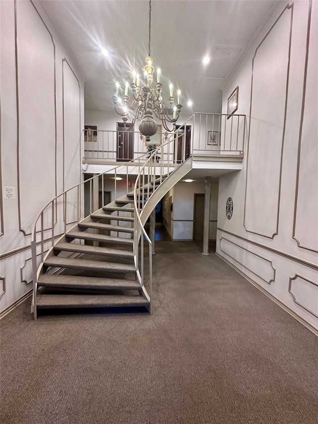 staircase featuring carpet flooring and a notable chandelier