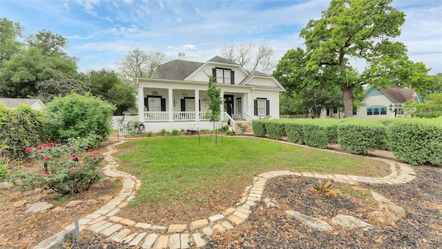 view of front facade with a front yard and covered porch