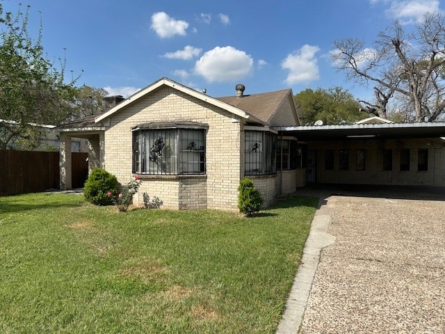 bungalow-style house with a front lawn and a carport