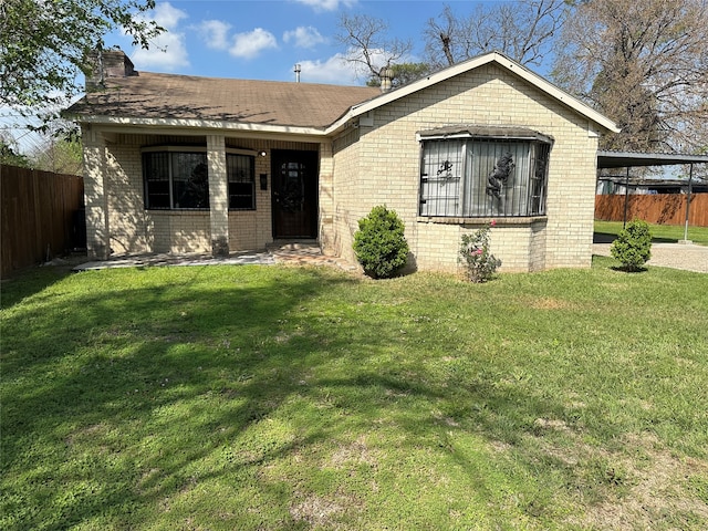 view of front facade with a carport and a front lawn